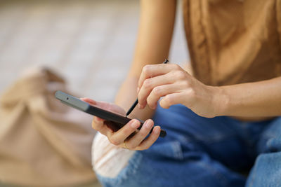 Midsection of woman using mobile phone