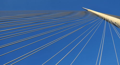 Low angle view of suspension bridge against sky