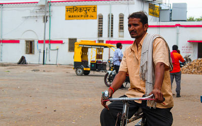 Man riding bicycle on road in city