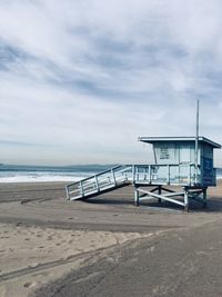 Lifeguard hut on beach against sky