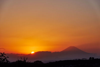 Scenic view of silhouette mountains against romantic sky at sunset