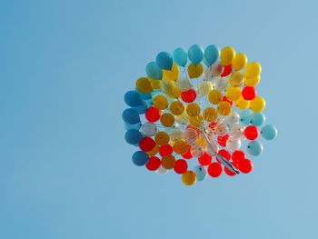 Low angle view of balloons against blue sky