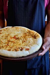 Close-up of hand holding pizza