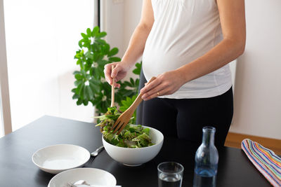 Midsection of woman holding food at home