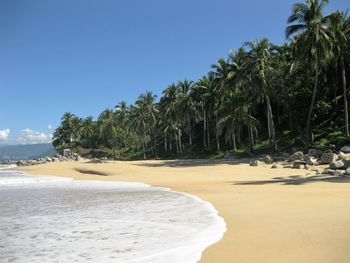 View of calm beach against blue sky