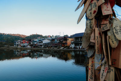 Buildings by river against clear sky