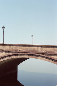 View of bridge over street against clear blue sky