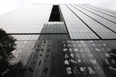 Low angle view of modern glass building against sky