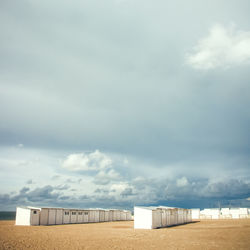 Scenic view of beach huts against sky