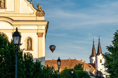 Low angle view of trees and buildings against sky