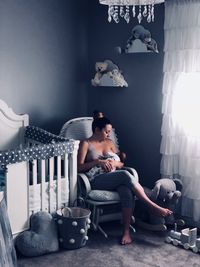 Mother breastfeeding baby in bedroom at home