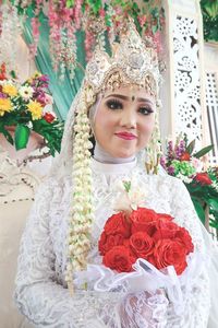 Portrait of bride in traditional clothing holding bouquet