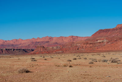 Scenic view of desert against blue sky