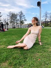 Woman sitting on grass in field