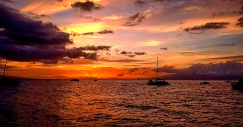Sailboats sailing in sea against sky during sunset