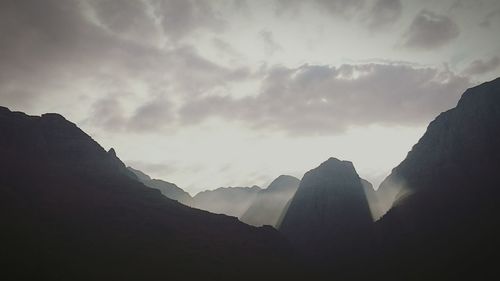 Scenic view of mountains against cloudy sky