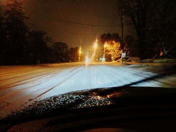 Close-up of illuminated car on road against sky at night