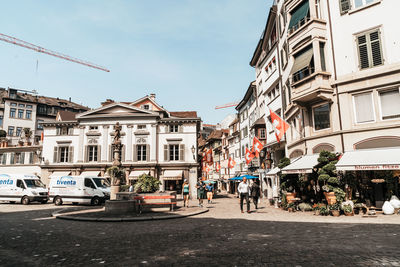 View of city street and buildings against sky