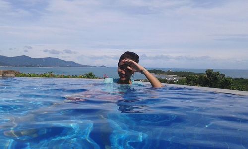 Portrait of young woman in infinity pool