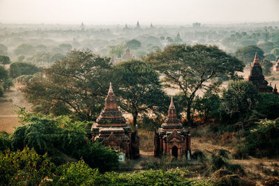 View of temple against trees and building