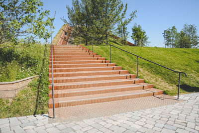 Staircase by footpath against sky