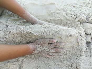 Close-up of hand on sand