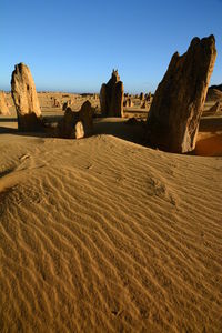 Sand dune in desert against clear sky