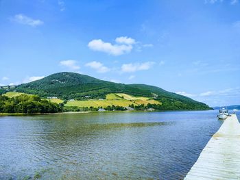 Scenic view of lake by mountains against sky