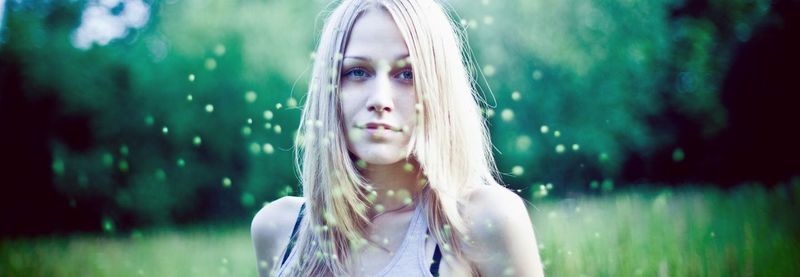 Portrait of young woman on field