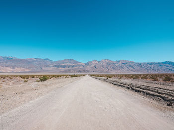 Scenic view of desert against clear blue sky