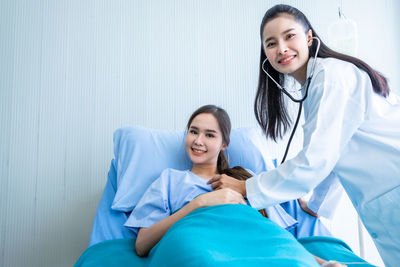 Portrait of female doctor examining patient at clinic