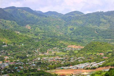 High angle view of field and mountains against sky