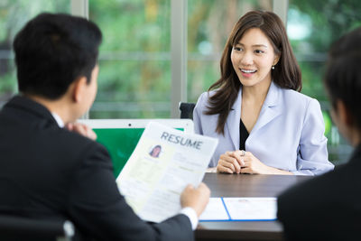 Colleagues sitting on table at office