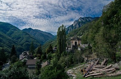 Panoramic view of trees and mountains against cloudy sky