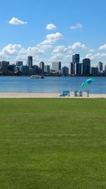 Scenic view of sea by cityscape against sky