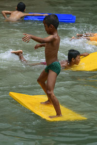 Shirtless boys playing in lake