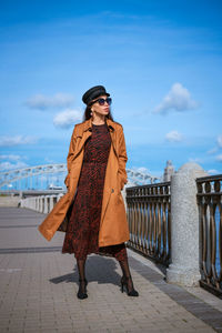 Beautiful young woman in a raincoat on the embankment