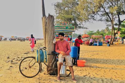 Man sitting on bicycle at beach