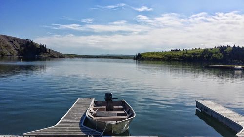 Boat moored at lake against sky