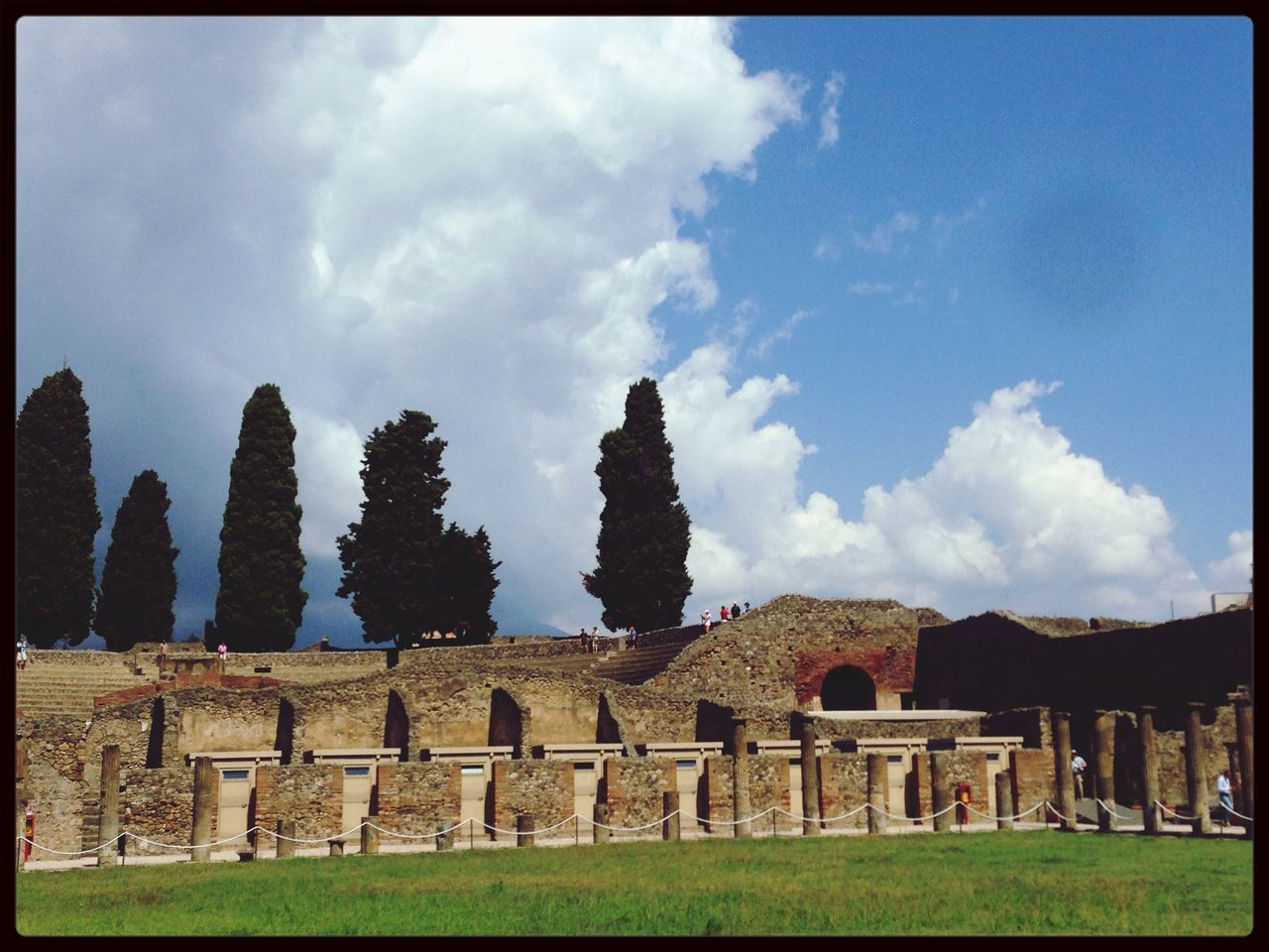 sky, architecture, built structure, transfer print, history, building exterior, old ruin, grass, cloud - sky, ancient, auto post production filter, the past, cloud, stone wall, old, ancient civilization, travel destinations, stone material, day, tourism