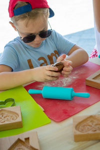 Bakers hand spraying egg-white on gingerbreads