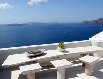 High angle view of table and seat on terrace against sea at santorini