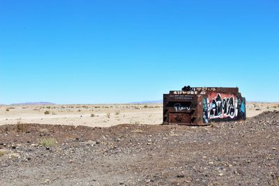 Old ruin on field against clear blue sky