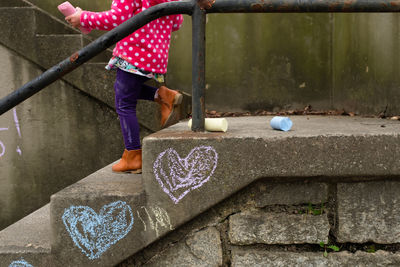 Girl drawing on stairs with chalk