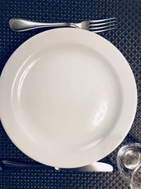 Directly above shot of empty plate with fork and spoon on table