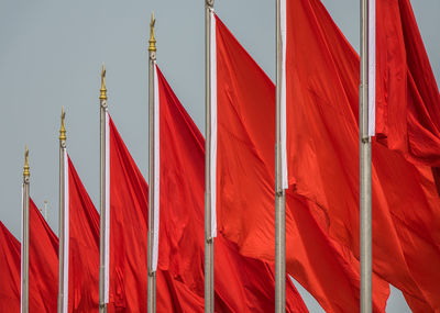 Chinese flag in red with yellow stars and waving in the wind blue sky