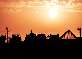 Silhouette city against sky during sunset