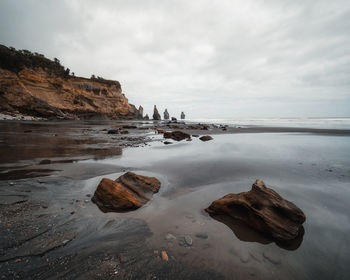 Rocks on beach against sky