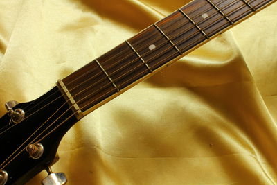Cropped image of guitar on fabric
