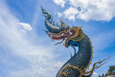 Low angle view of statue against temple against sky